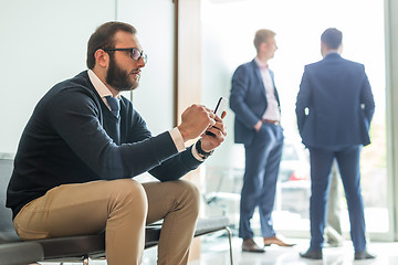 Image showing Businessman using smart phone while sitting in waiting room.