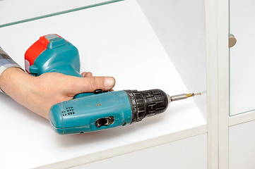 Image showing Worker using the electric screwdriver