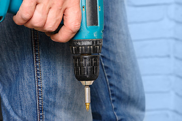 Image showing Worker holding the electric screwdriver