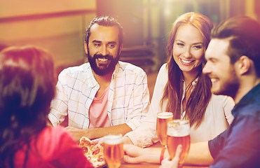 Image showing friends eating pizza with beer at restaurant