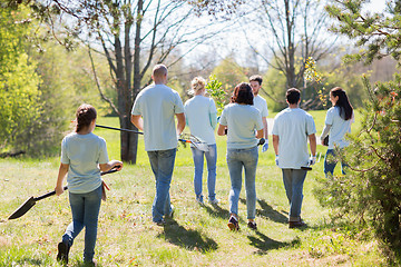 Image showing happy volunteers with seedlings and garden tools