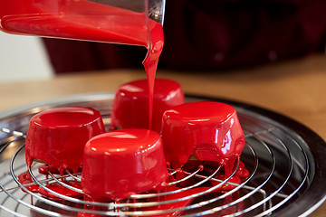 Image showing jug pouring glaze to cakes at pastry shop