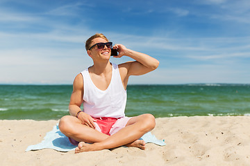 Image showing smiling man calling on smartphone on summer beach