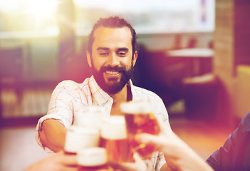 Image showing man clinking beer glass with friends at restaurant