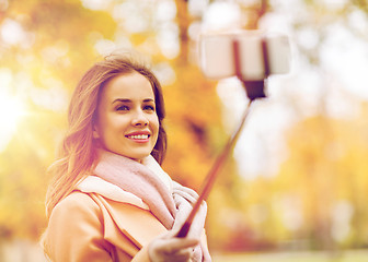 Image showing woman taking selfie by smartphone in autumn park