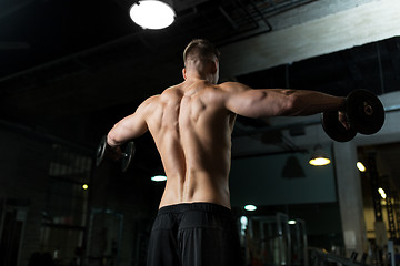 Image showing close up of man with dumbbells exercising in gym