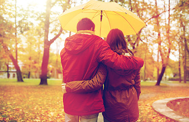 Image showing happy couple with umbrella walking in autumn park