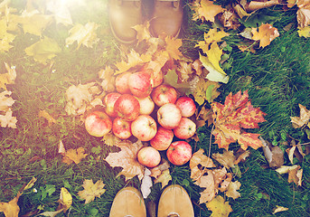 Image showing feet in boots with apples and autumn leaves