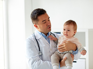 Image showing doctor holding crying baby at clinic