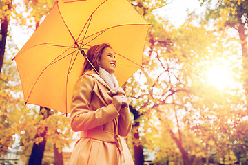 Image showing happy woman with umbrella walking in autumn park