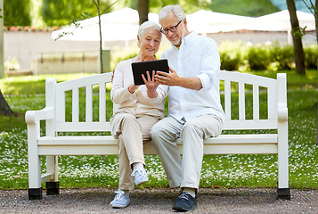 Image showing happy senior couple with tablet pc in city park