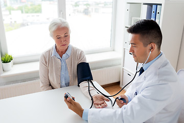 Image showing senior woman and doctor with tonometer at hospital