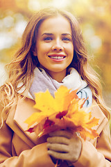 Image showing beautiful woman with maple leaves in autumn park