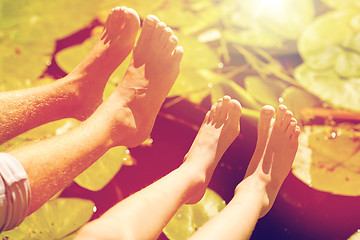 Image showing grandfather and grandson feet over river