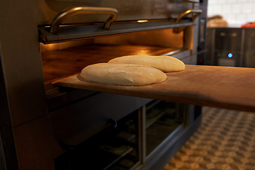 Image showing yeast bread dough on oven tray at bakery kitchen