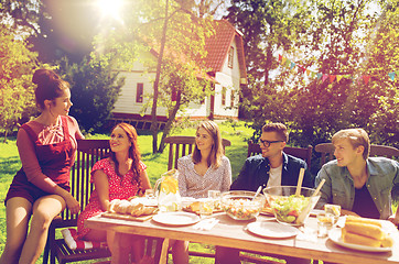 Image showing happy friends having dinner at summer garden party