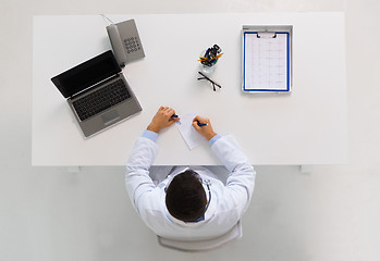 Image showing doctor with prescription and laptop at clinic