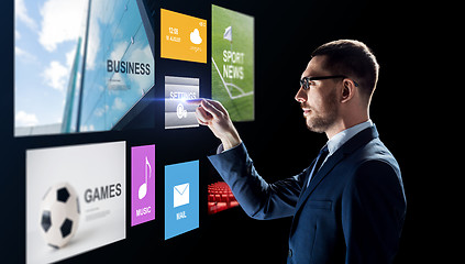 Image showing businessman with applications on virtual screen