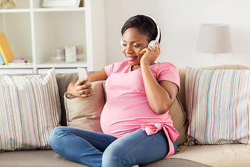 Image showing pregnant woman in headphones with smartphone