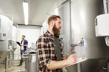 Image showing men with clipboard at craft brewery or beer plant