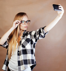 Image showing young pretty blond woman with smartphone posing smiling, making 