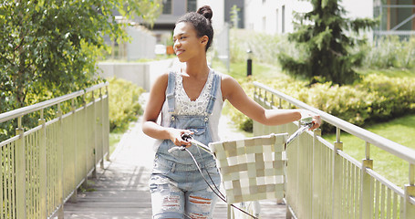 Image showing Young girl walking with bicycle