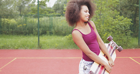 Image showing Trendy model posing with longboard