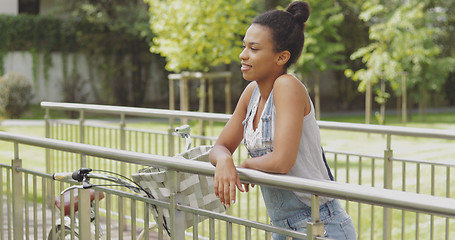 Image showing Woman with bicycle on bridge