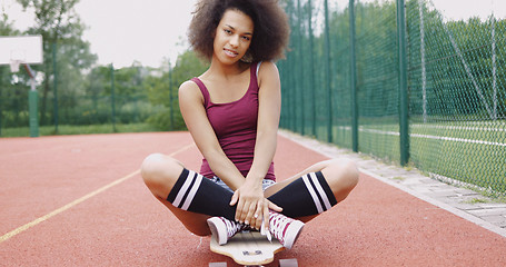 Image showing Charming model sitting on skateboard