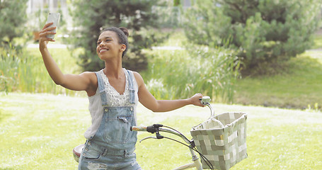 Image showing Cheerful woman taking selfie in park