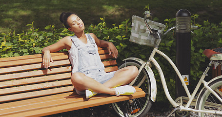 Image showing Woman enjoying sun on bench in park