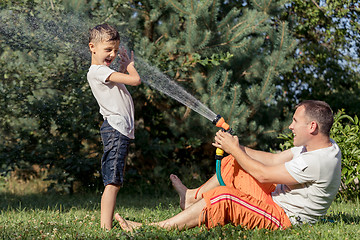 Image showing Happy father and son playing in the garden at the day time.
