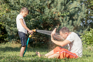 Image showing Happy father and son playing in the garden at the day time.