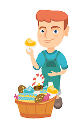 Image showing Boy holding a cupcake and stroking his belly.