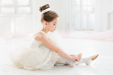 Image showing The little balerina in white tutu in class at the ballet school