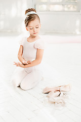 Image showing The little balerina in white tutu in class at the ballet school