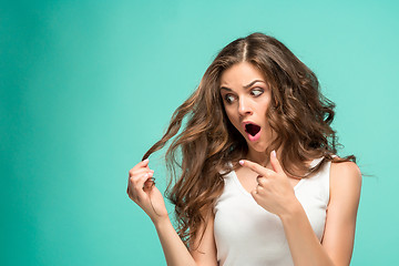 Image showing Frustrated young woman having a bad hair on blue