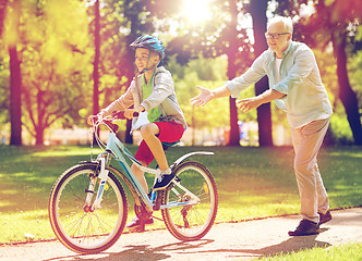 Image showing grandfather and boy with bicycle at summer park