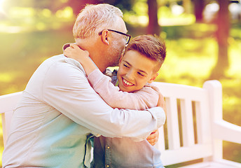 Image showing grandfather and grandson hugging at summer park