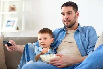 Image showing father and son with popcorn watching tv at home