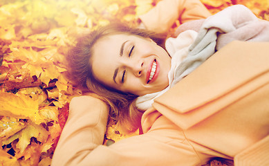 Image showing beautiful happy woman lying on autumn leaves