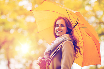 Image showing happy woman with umbrella walking in autumn park