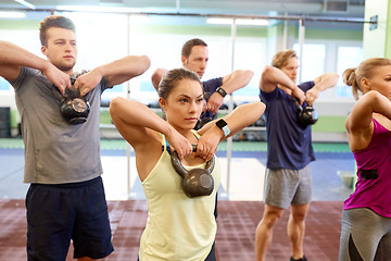 Image showing group of people with kettlebells exercising in gym