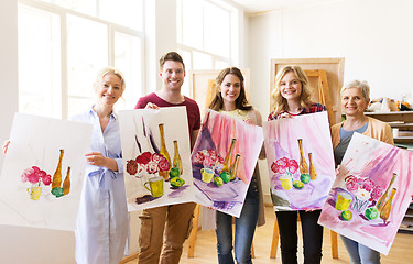 Image showing group of artists with pictures at art school