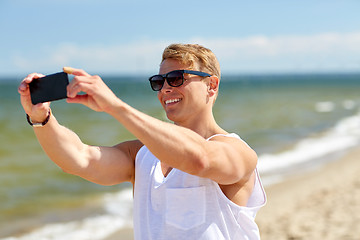Image showing man taking selfie by smartphone on summer beach