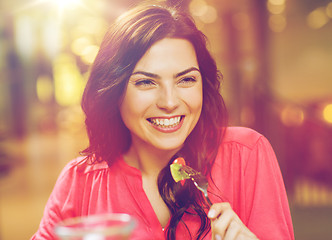 Image showing happy young woman having dinner at restaurant