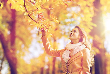 Image showing beautiful happy young woman walking in autumn park