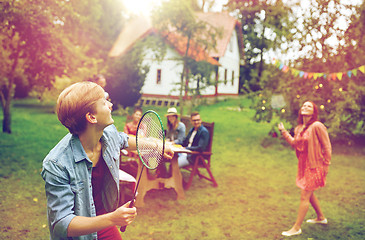 Image showing happy friends playing badminton at summer garden