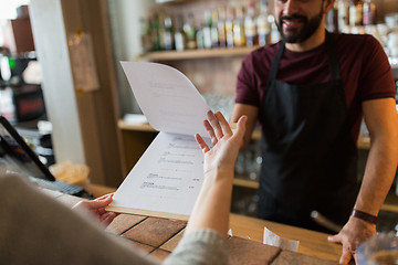 Image showing bartender and customer menu at bar
