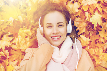 Image showing woman with headphones listening to music in autumn
